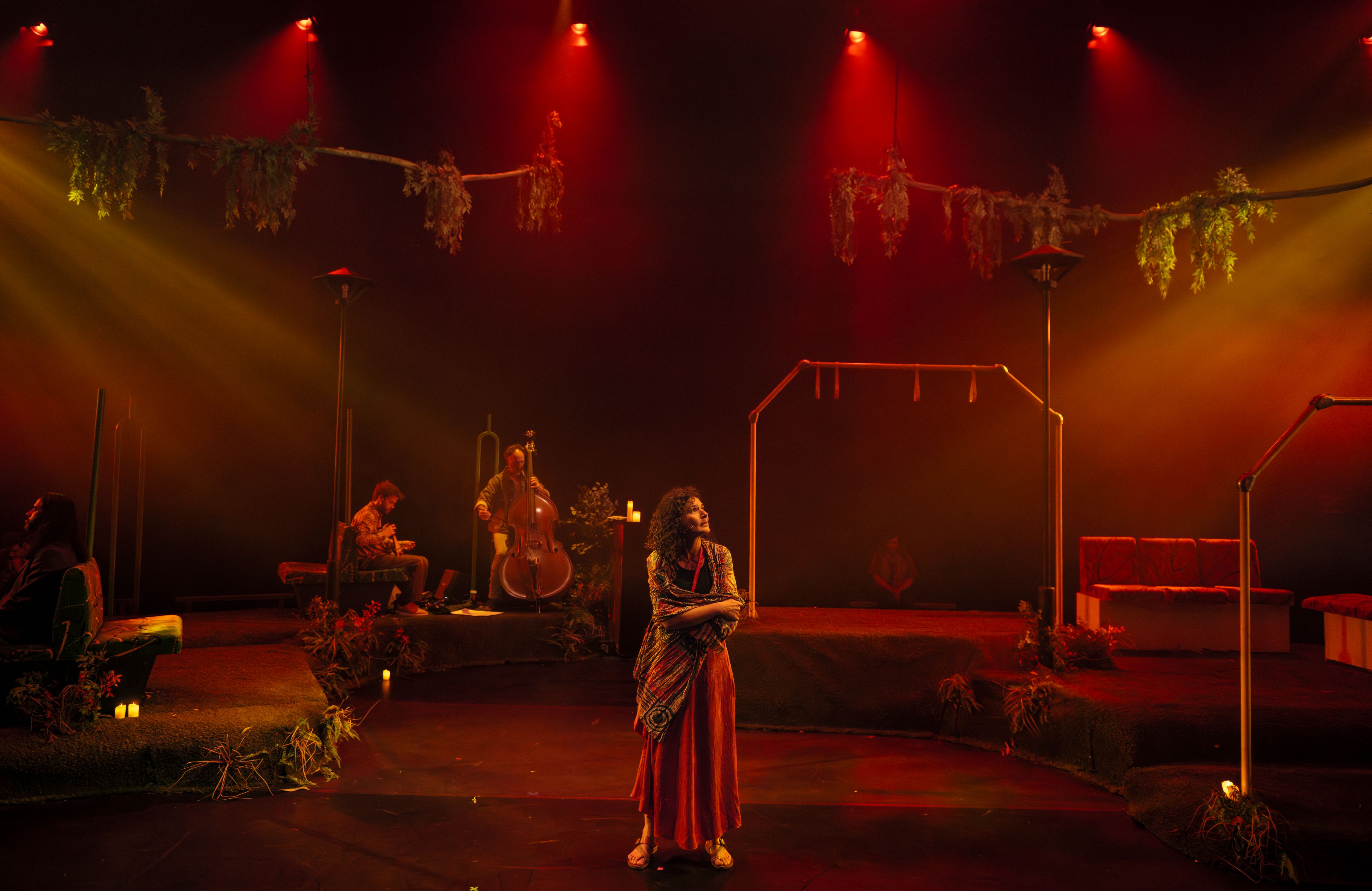 A woman stands centre stage with musicians behind her.