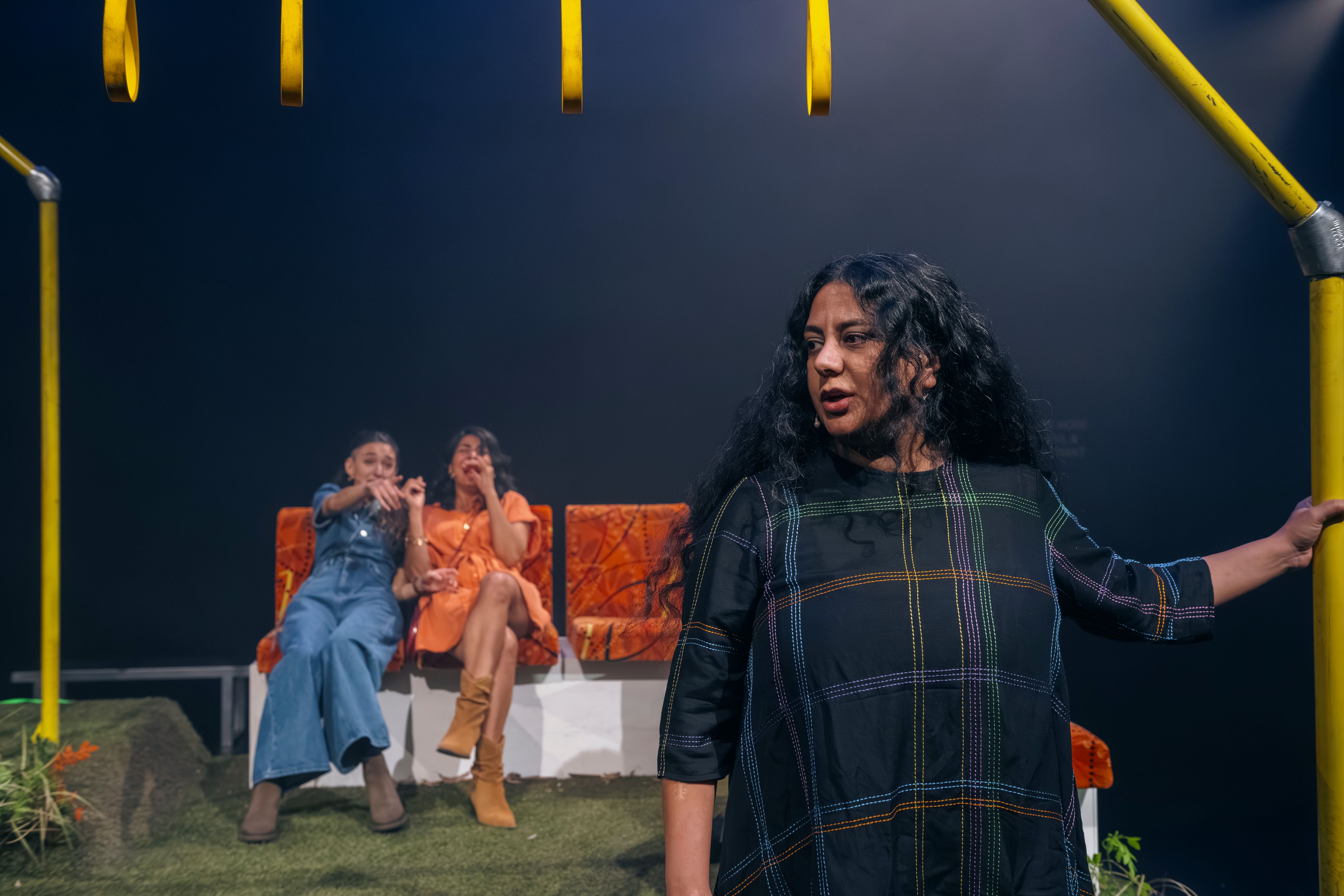 Three people on stage, the set is a Melbourne tram