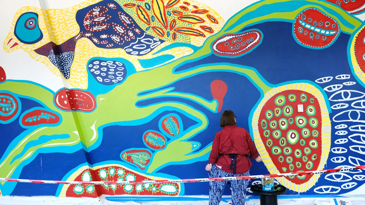 Emily Crockford painting a mural for Westpac Concord. 2018. Photo by Mamie Chen