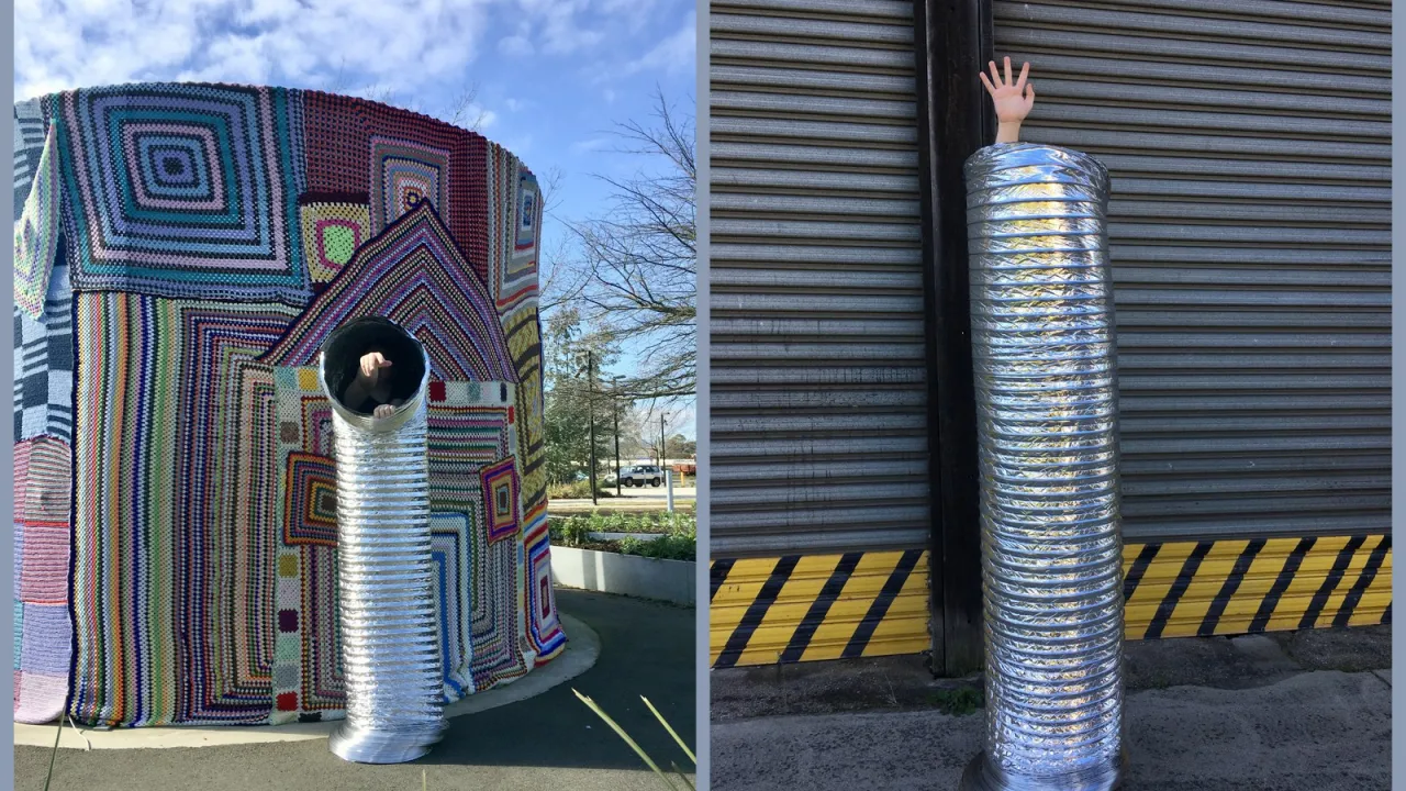 Hey You Help Interweave Arts Studio - Image of Artist Lewis's hand in a silver pipe in front of a crocheted covered water-tank installation titled Cozy by Interweave Arts.