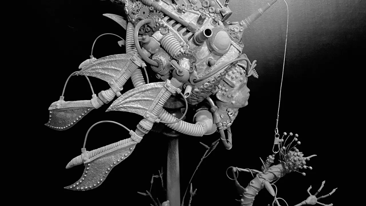 "Bio-mech no. 1" A grayscale image of a bio-mechanical sculpture depicting a marine creature made with recycled materials and found objects. The creature is transporting a smaller marine animal on a cable and the sculpture is mounted on a rod which is surrounded by plant life.