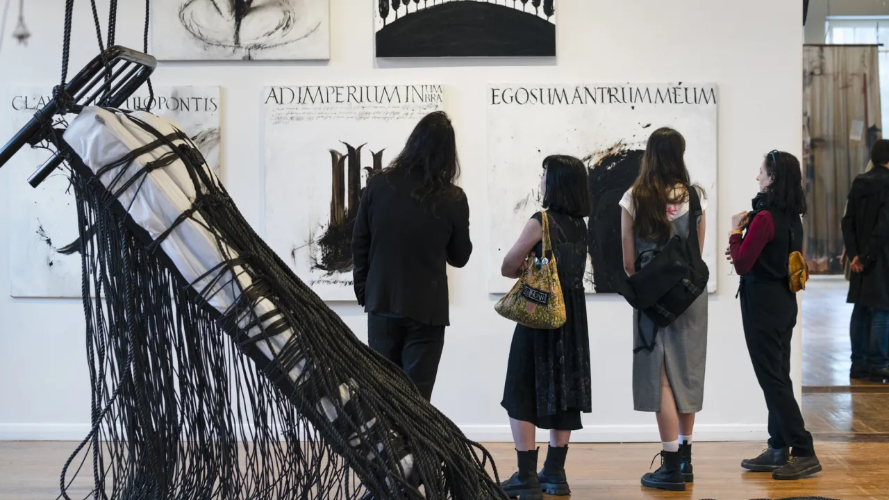 "Visitors viewing contemporary artworks at NotFair 2023, with large black-and-white paintings and installation in a bright gallery space.