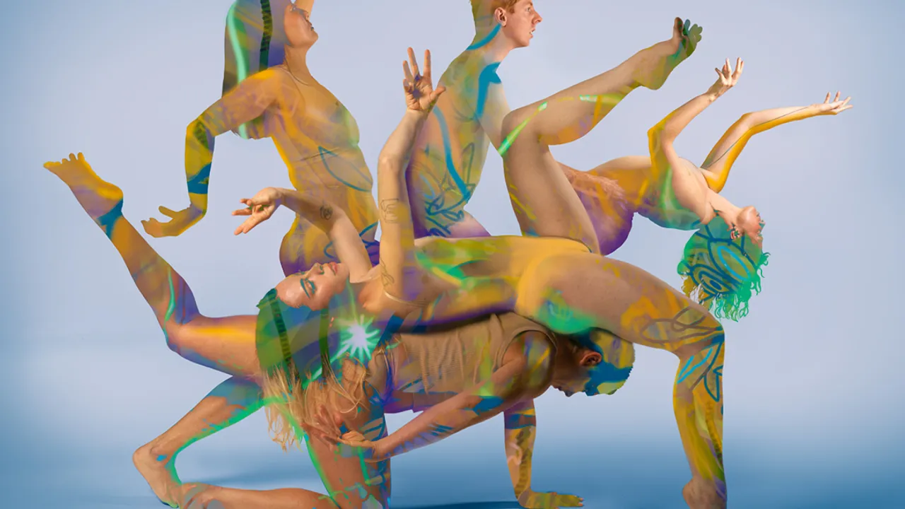 Five dancers intertwine their bodies to create a shape where hands, feet, legs and torso extend from a central position. Their skin is overlayed with hand drawn artwork by Arabella Walker, on a bright blue backdrop.