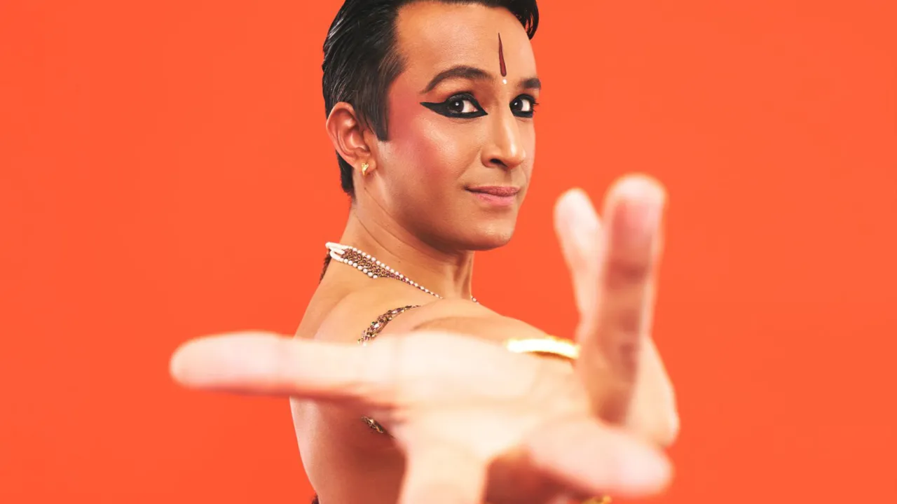 Indian classical dancer wearing green sari, holding alapadma hand gesture to the camera 