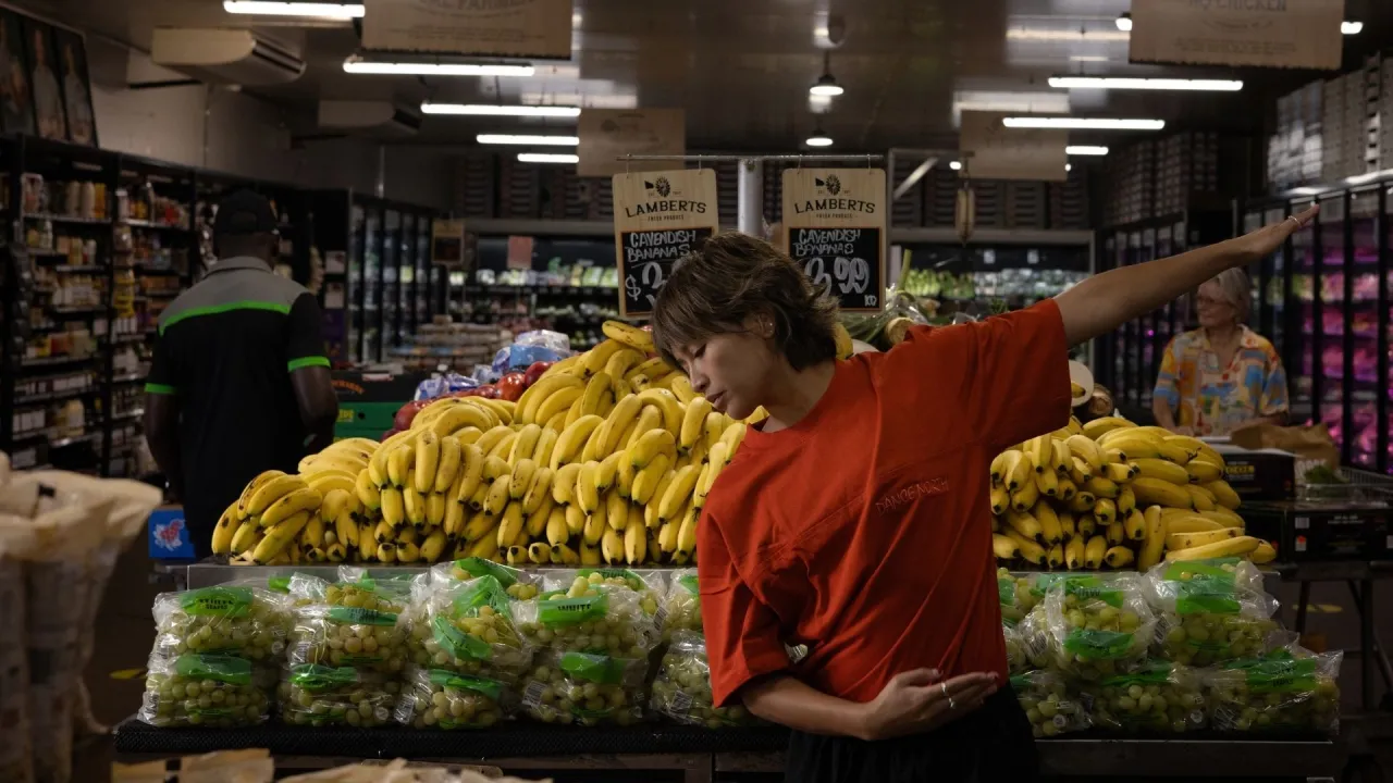 Image of a dancer in a red shirt in a supermarket setting