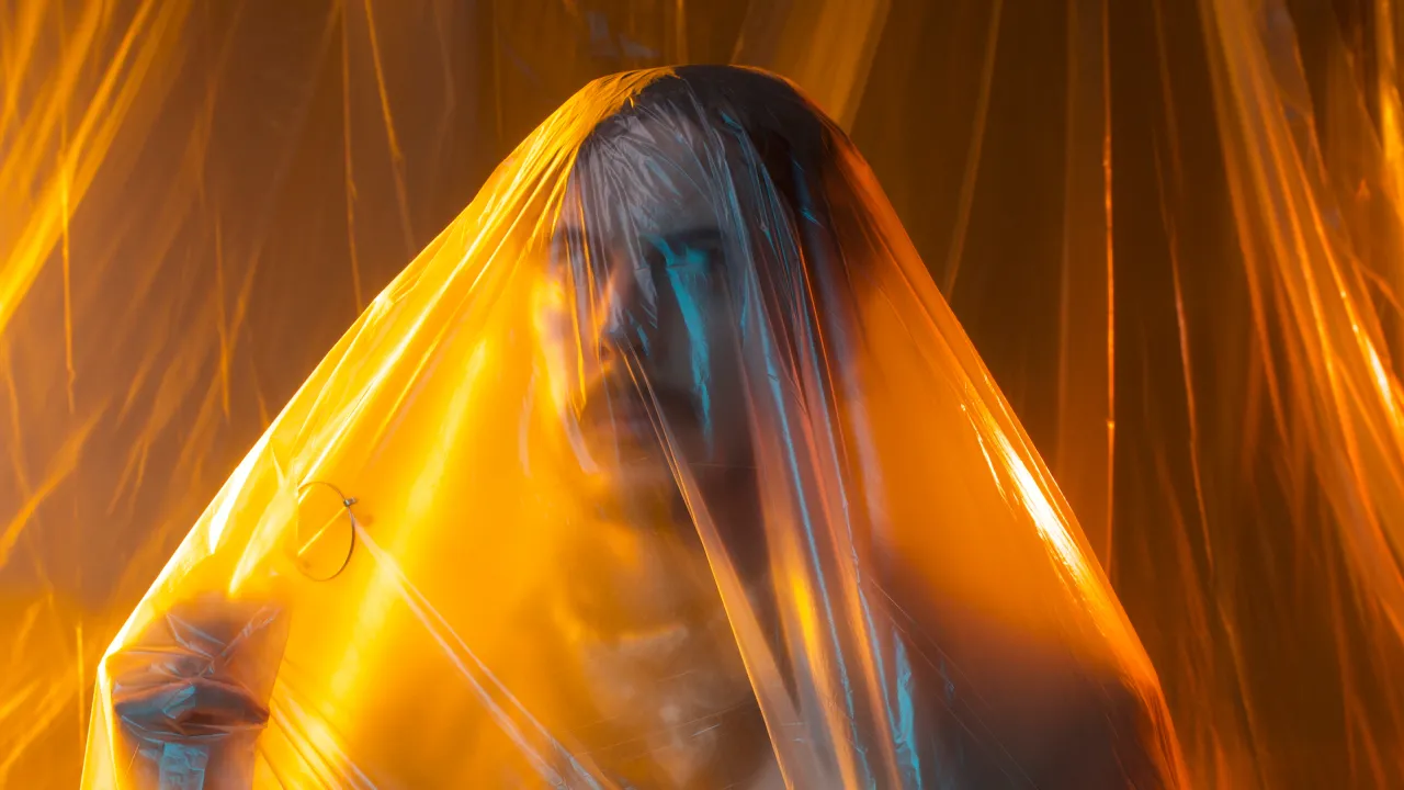 Brendan Maclean trapped in plastic wrap.