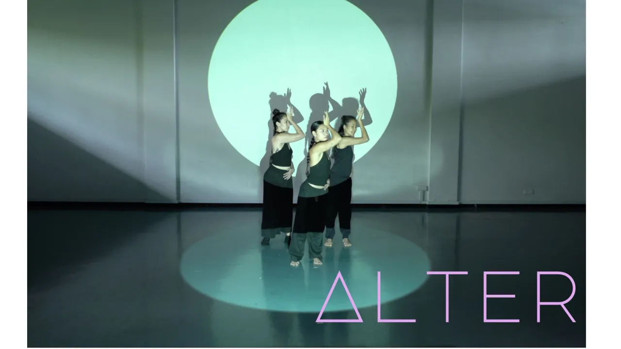 Three women standing in a circular pool of light
