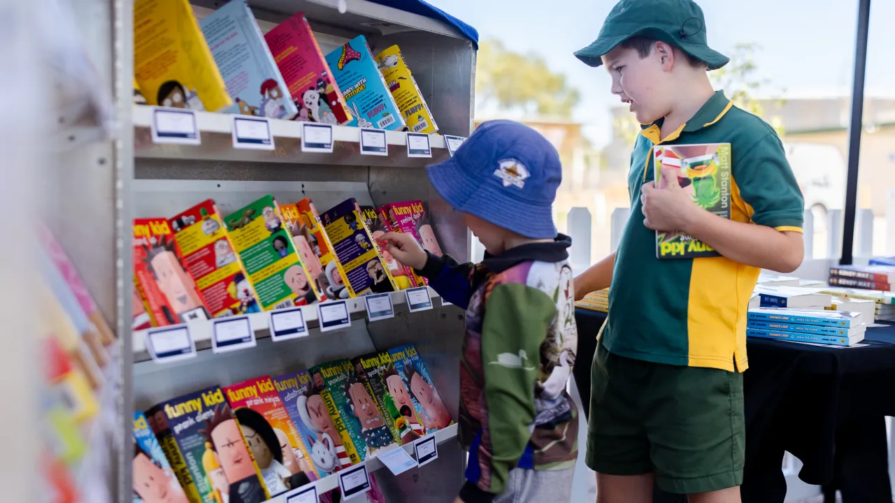 Two children selecting a book from bookshop
