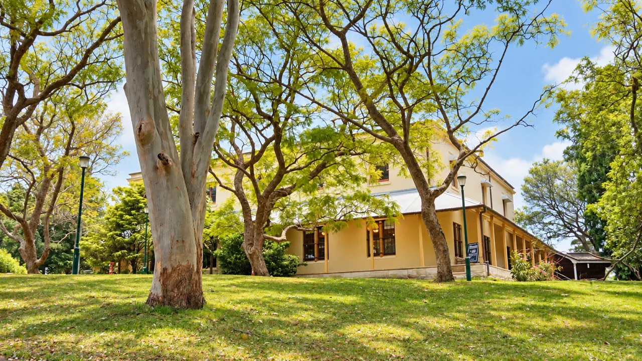 Historic house contained in a park, photographed on a bright sunny day with trees in the foreground