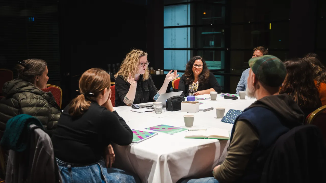 In this image we see (centre) playwright Sean Dowling delivering her writing masterclass 'Shaping Writing From Personal Experience” sourround by happy and interested participants..
