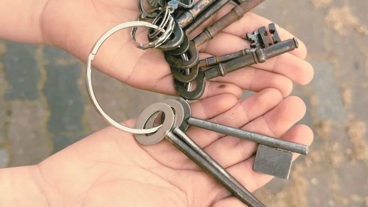 A child’s hands holding a vintage ring of keys