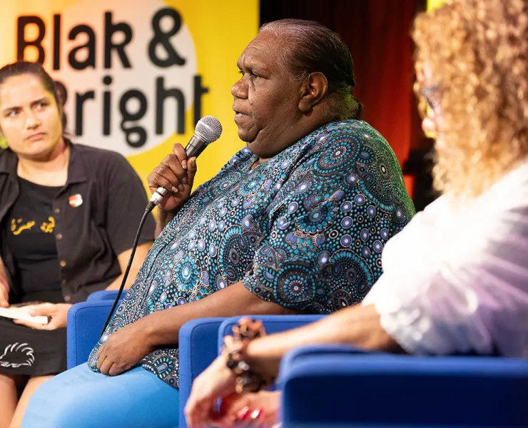 Three seated women speaking onstage at Blak & Bright 2024