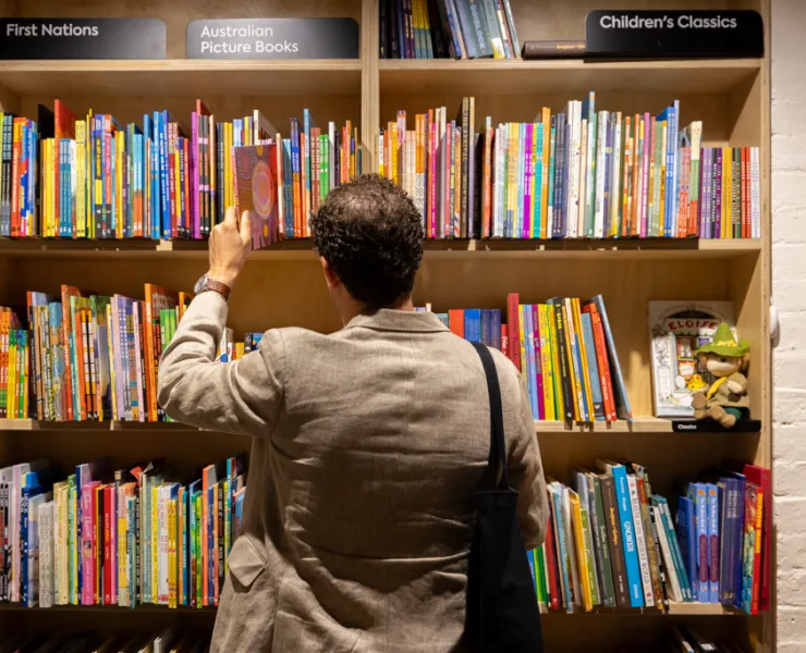 Photo of a person browsing a shelf full of books