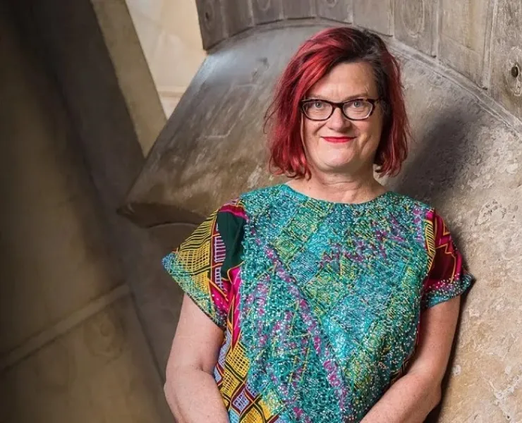A photo of Fiona Winning, a woman with red hair and glasses, smiling
